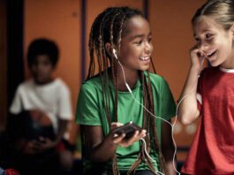 The little soccer players hanging out with music in a locker room before a training