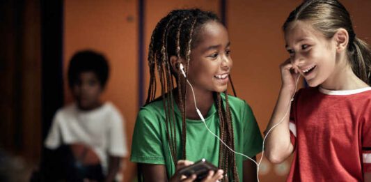 The little soccer players hanging out with music in a locker room before a training