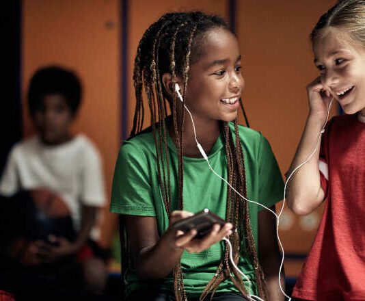 The little soccer players hanging out with music in a locker room before a training