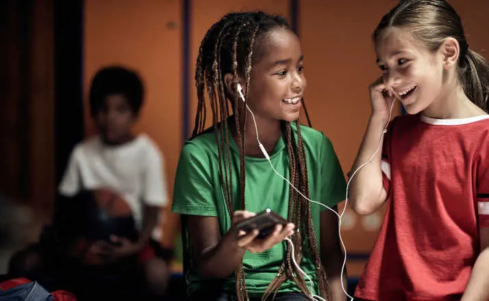 The little soccer players hanging out with music in a locker room before a training